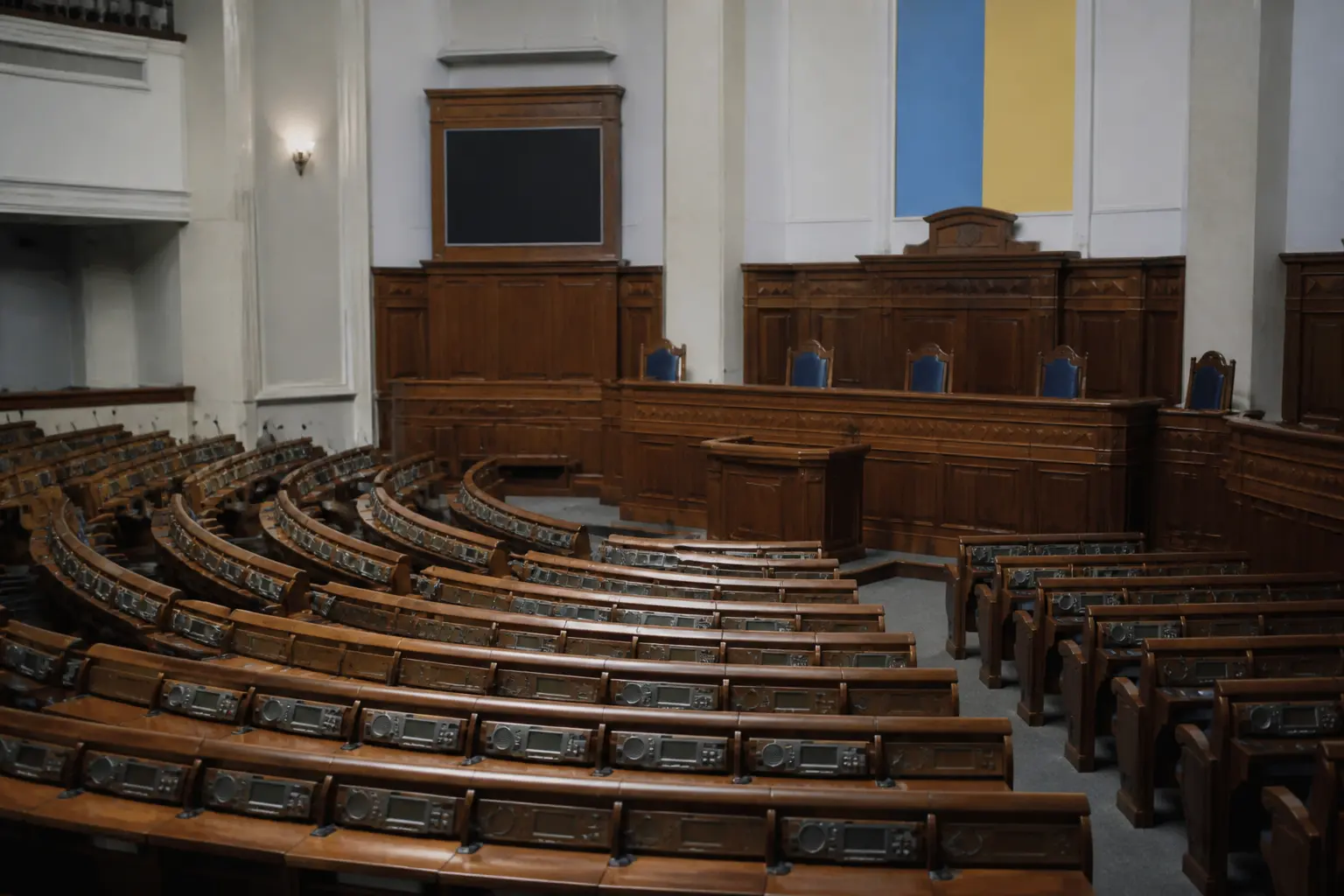 Зал засідань парламенту з рядами столів і мікрофонами