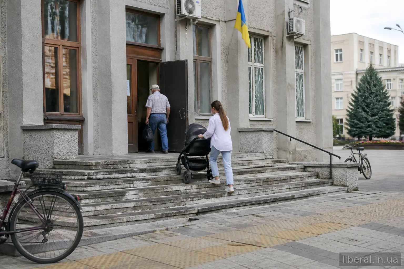 Мешканці заходять до будівлі місцевої ради в невеликому місті